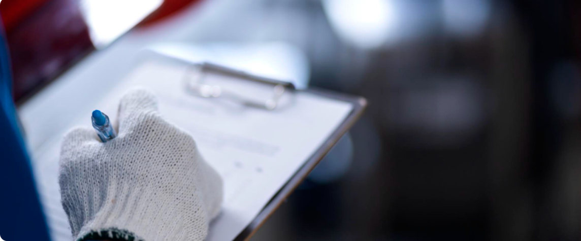 A gloved hand holding a clipboard