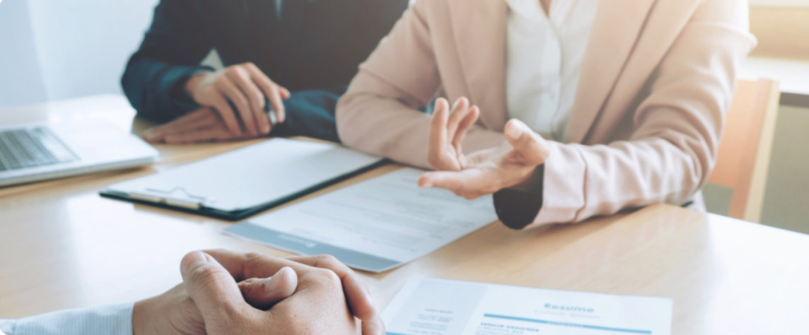 Two people discussing a contract across a desk
